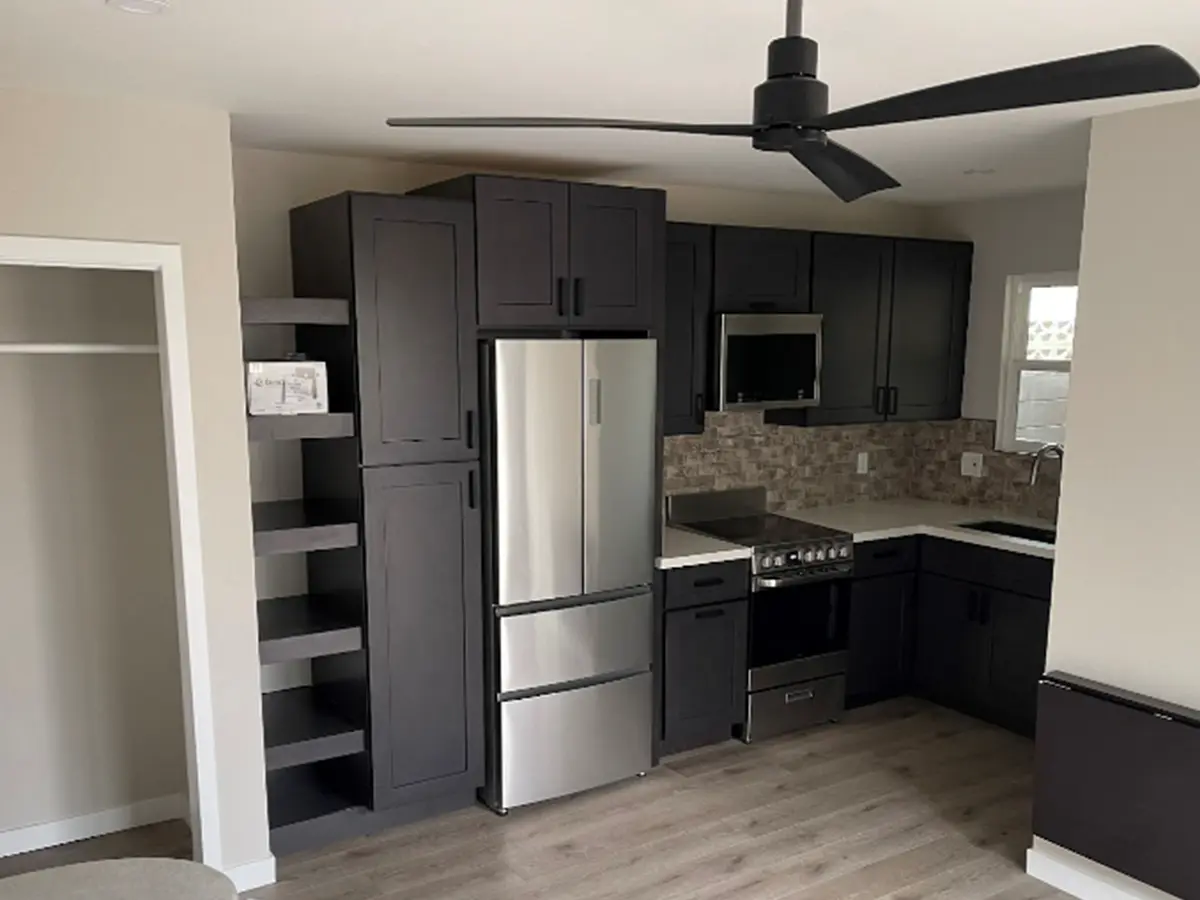 Black kitchen cabinets with silver appliances