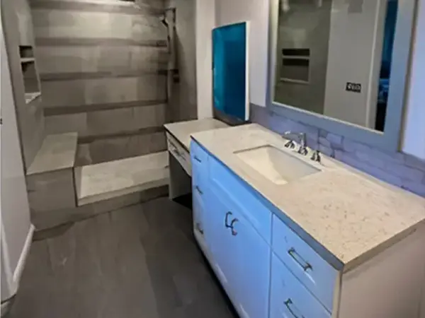 A small bathroom with a shower and a white vanity