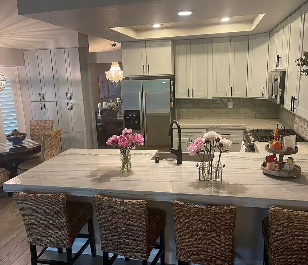 Beautiful light gray kitchen cabinets with a quartz countertop and flowers