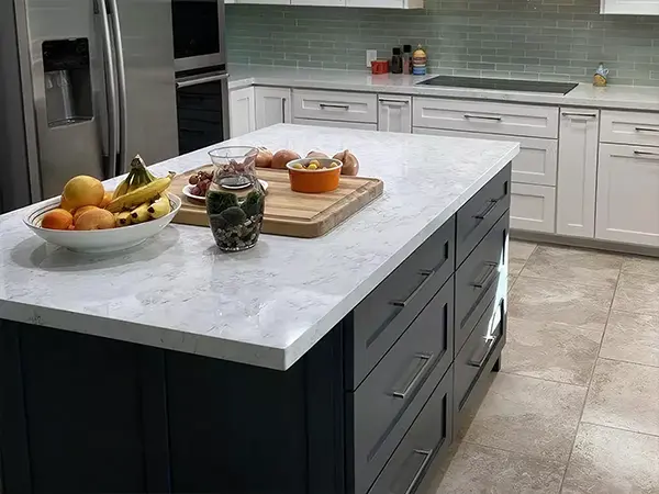 A tile floor in a kitchen with quartz countertops and white and black cabinets
